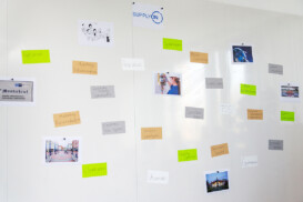 Auf einem Whiteboard werden farbcodierte Notizen und Fotos angezeigt, die in Gruppen angeordnet sind und mit Beschriftungen wie „Highschool“, „FOS“, „Universität“ und berufsbezogenen Begriffen auf Deutsch versehen sind.