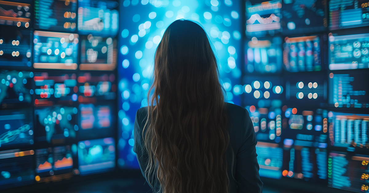 [woman standing in front of dozens of analytics monitors] Transform your supply chain with seamless buyer-supplier collaboration