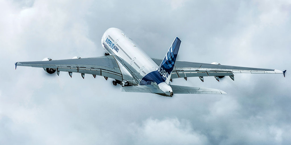 An Airbus A380 airplane with A380 markings on the tail, maintained by expert MRO services, is flying upward through a cloudy sky.