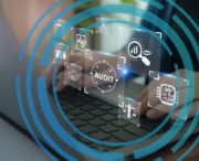 Person typing on a laptop with virtual audit-related icons, such as graphs and checklists, overlaying the image in a circular digital pattern.