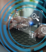 Person typing on a laptop with virtual audit-related icons, such as graphs and checklists, overlaying the image in a circular digital pattern.