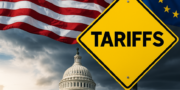 A yellow road sign with the word Tariffs in front of the U.S. Capitol dome, with American and European Union flags in the background.