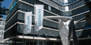 Siemens company flags and modern sculpture in front of a Siemens office building.