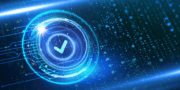 A futuristic digital interface displays a large checkmark inside a glowing blue circular graphic, surrounded by abstract light effects and floating data particles.