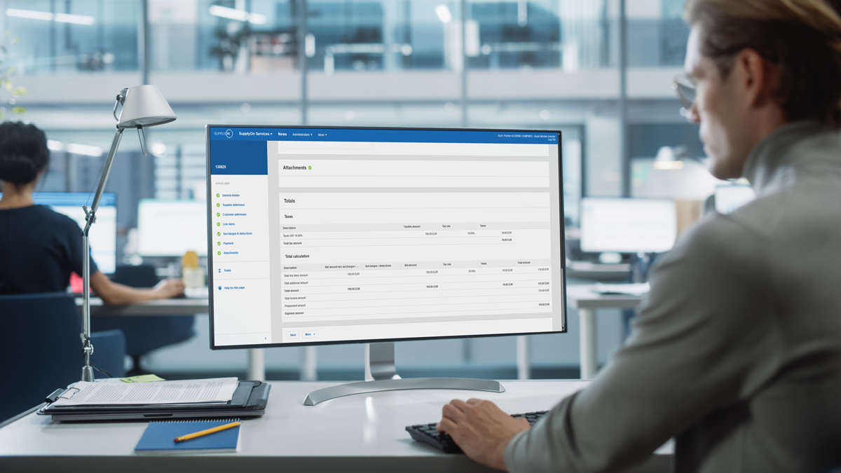 A person at a desk in a modern office looks at a computer screen displaying a web-based business management dashboard.