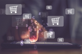 A hand touches a smartphone screen with digital shopping trolley and currency symbols floating above, representing online shopping and e-commerce transactions.
