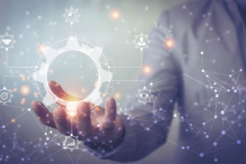 A person in a suit holds a glowing digital gear with technology and network icons, representing innovation and digital transformation.