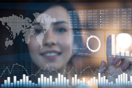 A woman interacts with digital data visualisations, including graphs, charts, and a world map, displayed on a transparent screen.